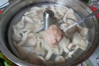 当汤水再次沸腾后，取出备好的虾滑，用小勺子挖成小球，下水汤内。