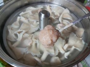 当汤水再次沸腾后，取出备好的虾滑，用小勺子挖成小球，下水汤内。