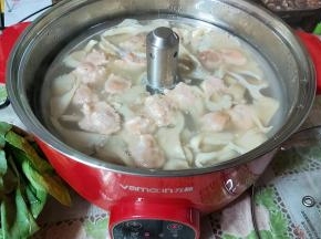 速度的把虾滑下至锅内，转中小火慢慢煮开。