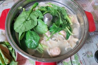 当虾滑煮至颜色变浅后，把菠菜下入锅内。