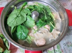 当虾滑煮至颜色变浅后，把菠菜下入锅内。