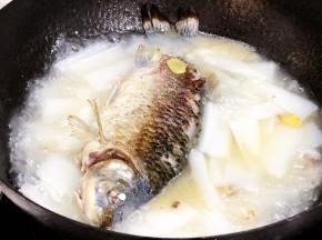 将煎好的鱼加入到萝卜汤中，继续大火烧开