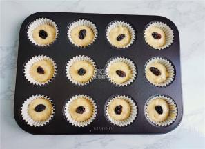 .取学厨的玛芬模具，铺入纸托，把裱花袋中面糊挤入3/2放入果脯。