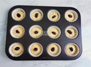 .取学厨的玛芬模具，铺入纸托，把裱花袋中面糊挤入3/2放入果脯。