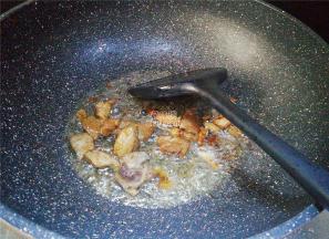 葱油微热后，把猪肉切小块倒入翻炒，炒制变色撒入点料酒煸炒。