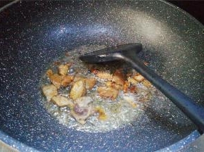 葱油微热后，把猪肉切小块倒入翻炒，炒制变色撒入点料酒煸炒。