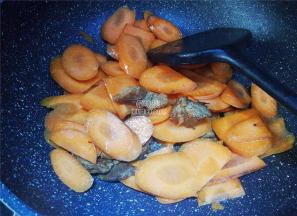 胡萝卜去皮切片，倒入锅中一起翻炒，撒入点盐和生抽调味。