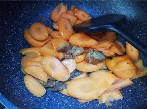 胡萝卜去皮切片，倒入锅中一起翻炒，撒入点盐和生抽调味。