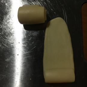 静至好侧边收口朝下！压平继续擀至长舌状！再次从上端卷至下端！静至20分钟！