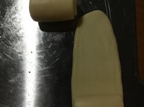 静至好侧边收口朝下！压平继续擀至长舌状！再次从上端卷至下端！静至20分钟！