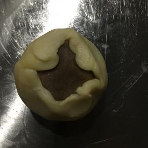 再用擀面杖擀成饺子皮状。放入馅料，以推的手法将面皮推至收口处，收紧收口！