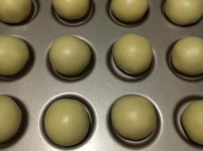 包好的蛋黄酥摆好放进学乌比派模具，刷上全蛋液，撒上芝麻
