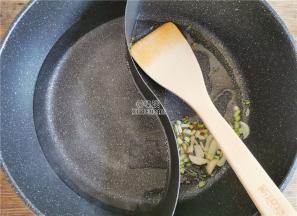 首先把葱绿和葱白切好，我备了鸳鸯锅，一边倒入适量食用油，升温后放入蒜片和葱白炒香。