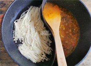 煮的清水沸腾后，放入洗净的金针菇汆烫，另一边倒入适量清水，加盖煮沸。