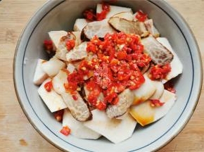 接着铺入两勺剁椒酱在上面，空隙处也填入一些。