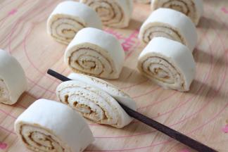 拿一个筷子，放到卷的中间，压筷子两头。摁压下去，切面就翻上来了。一个花卷就完成了。这样做，无需整形也能做出好看的花卷。