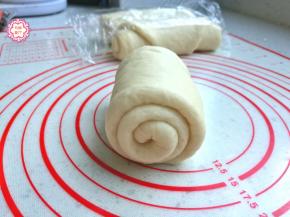 取一个面团，从中间向两端擀开，擀成长舌状，然后自上而下卷起来，贴边卷紧，不要留缝隙太大松松垮垮。卷好后竖向按扁，重复刚才的步骤，再擀卷一次，最后卷好的面团是图中的样子。
