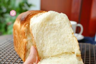 时间到了以后立刻出炉，我这个吐司，就是时间到了我没听到，过了20多分钟了才想起来，结果是有点缩腰了。及时出炉及时脱模是完全没有问题的，一点也不会塌陷缩腰。
软绵绵的日式大吐司就做好了，刚烤好的吐司外皮比较脆，但内芯非常绵软，非常好吃。面包从出炉就开始老化，所以晾凉后及时用保鲜袋密封保存，减少老化程度。早餐不知道吃啥？做个绵绵大吐司，撕着比切片好吃，绵软拉丝是它的特点