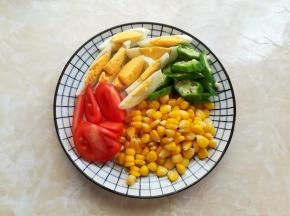 煮藜麦的时候，把番茄切小块，玉米剥粒，秋葵切小片，鸡蛋去壳切小块放一边备用
