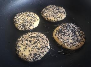取不粘平底锅，倒入一层薄薄的植物油加热至五分热，平铺依次放入小圆饼；（油温度不宜过高，芝麻容易煎焦）