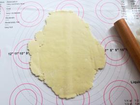 把混合好的奶粉面团取出来，放到干净的硅胶垫上，用擀面杖擀成1元硬币的厚度