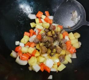 放入牛肉丁，放入半小勺盐，半小勺糖，一勺生抽，一勺咖喱粉翻炒均匀