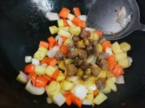放入牛肉丁，放入半小勺盐，半小勺糖，一勺生抽，一勺咖喱粉翻炒均匀