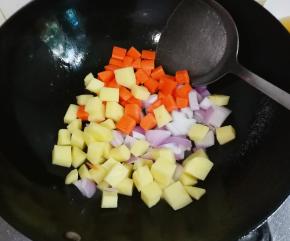 锅中余油放入洋葱，胡萝卜，土豆翻炒出香味