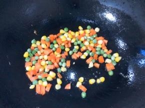 锅中底油，放入红萝卜，玉米豌豆翻炒至熟