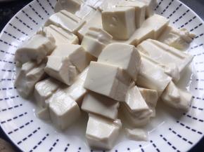 将内脂豆腐提前切好，放入碗中静置半小时左右，渗出豆腐中多余的水份；