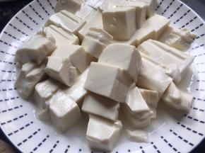将内脂豆腐提前切好，放入碗中静置半小时左右，渗出豆腐中多余的水份；