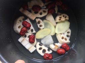 将藕块、红枣、冰糖、姜片都放入电饭煲内，倒入没过食材的清水；