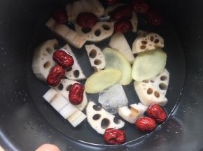 将藕块、红枣、冰糖、姜片都放入电饭煲内，倒入没过食材的清水；