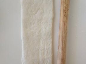 １３、将松弛好的面团擀开，翻面，压薄底边，长度与擀面杖差不多长就可以。