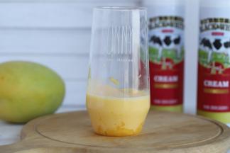 将芒果泥倒入盛有芒果粒的玻璃杯，留一点点最后装饰。