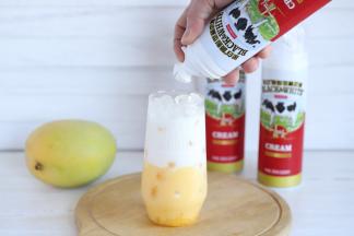 黑白喷射奶油轻轻摇晃，对准玻璃杯口喷上奶油。