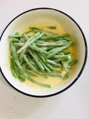 把豆角放入调好的糊中，让每个豆角都均匀的裹满糊糊。