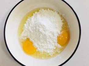 碗中打入两个鸡蛋，放入少许盐，适量的玉米淀粉。（淀粉的量根据蛋液的量来适当调整，面糊粘稠即可。）