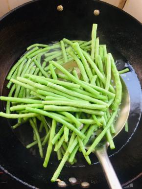 水烧开放入豆角焯水1分钟捞出，放在冷水中投凉沥干水分备用。