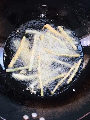 油温7成热，一个一个的放入豆角中火慢慢的炸。