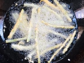 油温7成热，一个一个的放入豆角中火慢慢的炸。