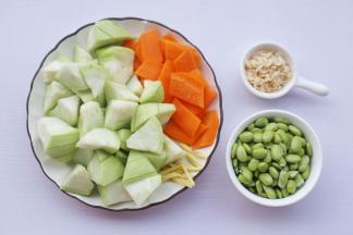丝瓜去皮切滚刀块，胡萝卜切菱形，毛豆剥粒洗净，虾米用滤网冲洗净，姜去皮切丝。