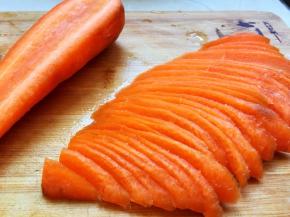 胡萝卜去皮从中间切开，切成半月牙薄片