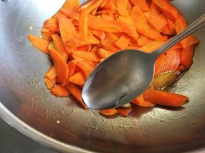转小火，沿锅边加入一汤匙水，盖盖，小火焖五六分钟，至胡萝卜片呈半透明状