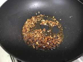 锅里热油，下蒜末爆香，再加入一勺酱油、一勺醋炒匀。