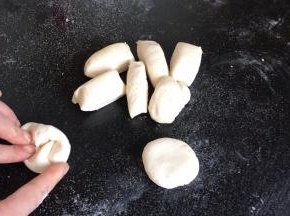 先取一部分白面分成合适的小面团，滚圆按成圆饼