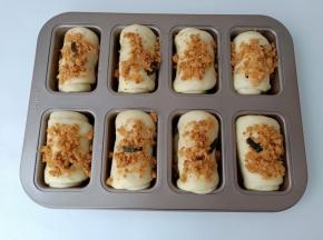 发酵好的面团表面喷一些水，撒上肉松【喷水更好地让肉松跟面团粘合在一起】