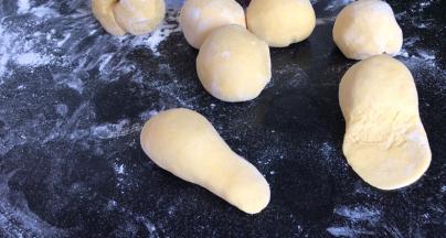 分成若干个小面团，再搓捏成一趟大一头小的长圆型，把小头压成薄饼