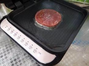 电饼铛预热，按“烤肉”键，入油，煎制牛排。煎好一面，再翻面。每一面的时间约2-3分钟。