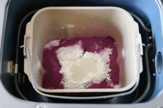 四周再倒入紫薯粉，粉中间挖个洞放入干酵母粉，启动面包机和面程序开始揉面；